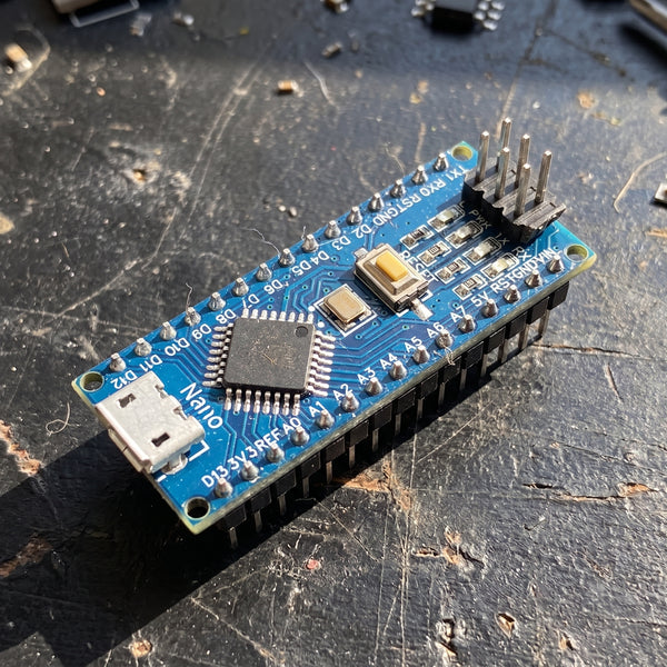 Arduino Nano blue microcontroller board front view showing USB port and pin headers