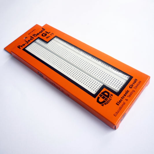 GL-12 breadboard in orange packaging lifestyle view showing white solderless breadboard
